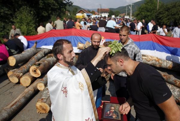 Srbski pravoslavni duhovnik opravlja verski obred ob srbskih barikadah na Kosovu.
