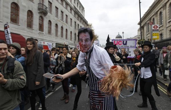 Protestnik z masko "mesarja" ministra Nicka Clegga.