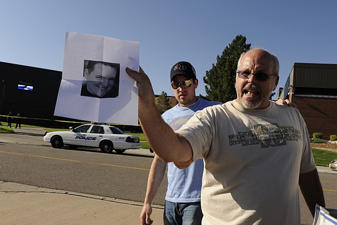 Moški novinarjem kaže fotografijo svojega sina, ki je pogrešan od streljanja.