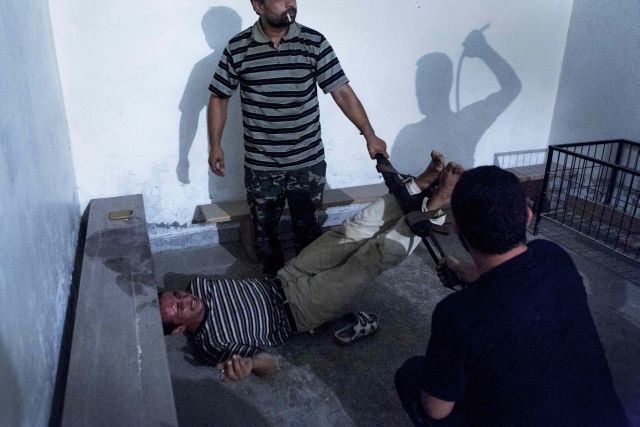 Emin Özmen iz Turčije je julija lani fotografiral sirske upornike med  zasliševanjem in mučenjem vohuna v Alepu. (foto:...