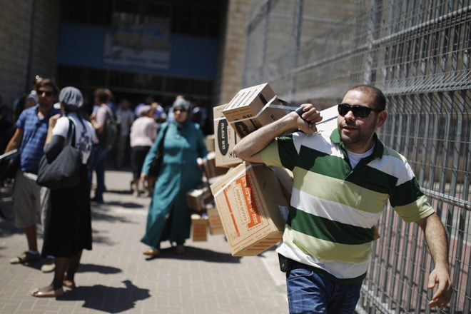 Izraelci se v strahu pred povračilnimi napadi Sirije v razdelilnih centrih že oskrbujejo s plinskimi maskami.  Foto: Reuters...