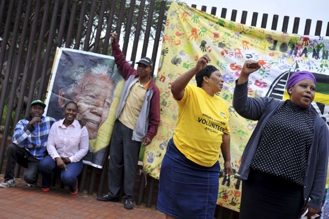 Ljudje se zbirajo tudi na ulici Wikazi v kraju Soweto, kjer je živel Mandela. (Foto: Reuters) 
