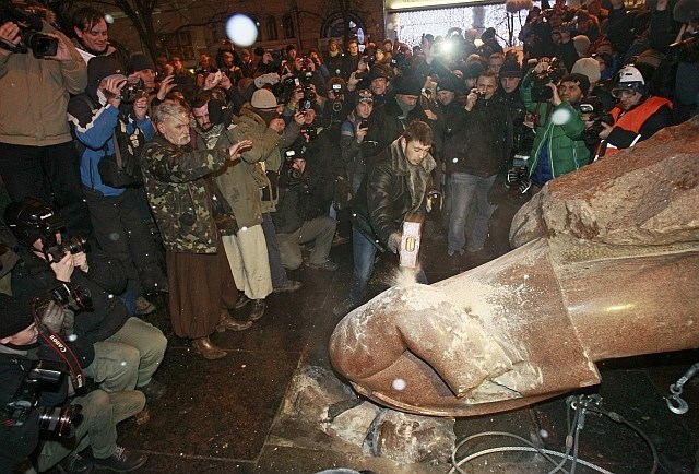 Protestniki razbijajo kip nekdanjega sovjetskega voditelja Vladimirja Lenina 