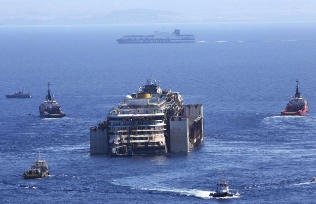 Nasedla potniška ladja Costa Concordia je začela svojo zadnjo pot izpred obale otoka Giglio proti pristanišču v Genovi. 