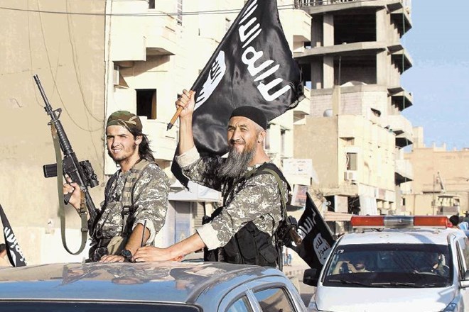 Člani Islamske države mahajo z njeno zastavo med parado v  sirski provinci Raka ob junijski razglasitvi kalifata.  