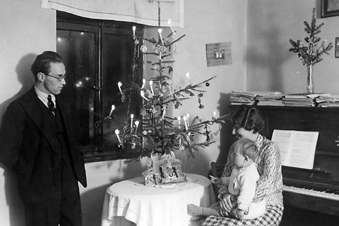 Značilen utrinek meščanskega praznovanja božiča prikazuje dr. Stanka Vurnika z družino ob božičnem drevescu. Fotografija je...
