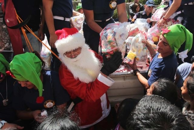 Gvatemalski gasilec Hector Chacon se je po vrvi spustil z mosta in oblečen v Božička otrokom delil darila. Gasilci otrokom iz...