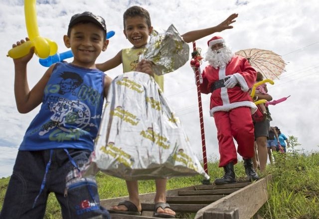 Predstavniki skupine Prijatelji Božička v bližini Amazonskega gozda razdeljujejo darila revnejšim otrokom. (Foto: Reuters) 
