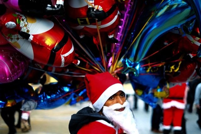Ciper: V Božička oblečen fant prodaja balone. (Foto: AP) 