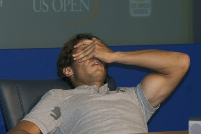 Rafael Nadal se je takole prijel za glavo, nato pa od bolečin zdrsnil s stola.