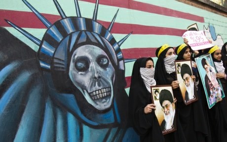 Iranske študentke stojijo pred anti-ameriškim grafitom na zgradbi bivše ameriške ambasade v Teheranu.
