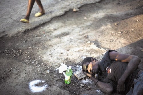 Tridesetletni Antonio Joseph, ki je zbolel za kolero, leži ob cesti v predmestju Cap Haitiena na arhivski fotografiji iz...