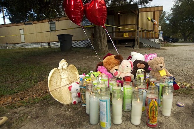 Sveče, igrače in baloni pred prikolico, v kateri se je pripetila tragedija.