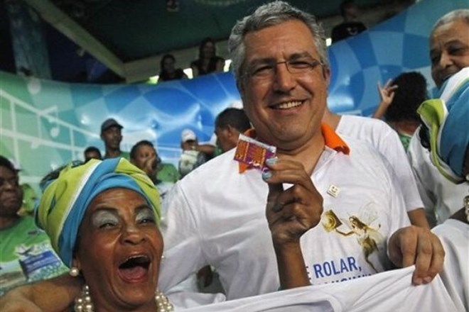 Brazilski minister za zdravje z eno izmed plesalk, ki drži brezplačen kondom.