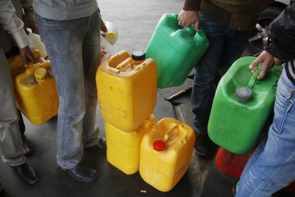 Palestinci s kanticami čakajo na gorivo.