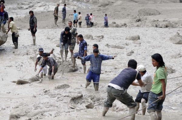 Reševanje žrtev narasle reke v Nepalu.