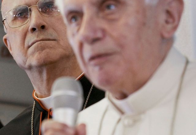 Kardinal Bertone  (levo) je samo navidezno skrit v papeževi senci.