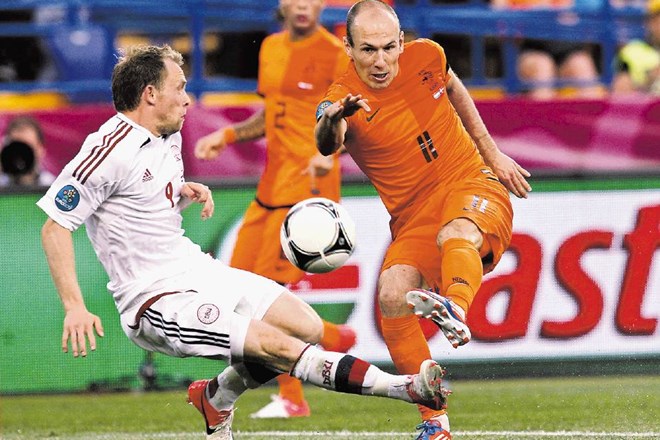 Dvoboj junaka in osmoljenca. Danski vezist Michael Krohn-Dehli (levo) je  dosegel edini gol na tekmi v Harkovu. Nizozemski...