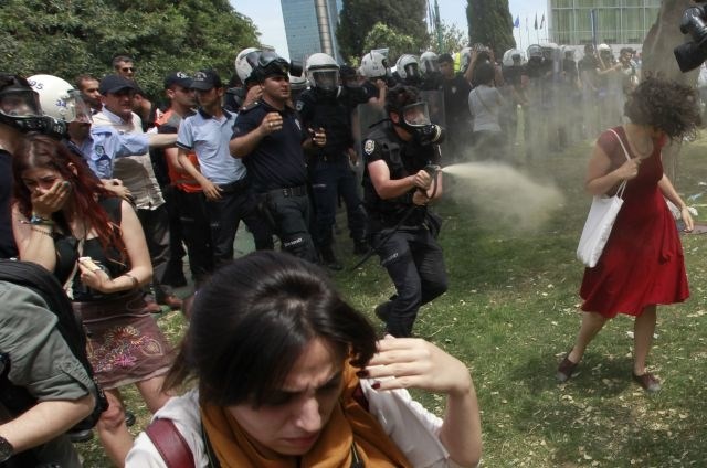 Policisti s solzivcem razganjajo protestnike. 