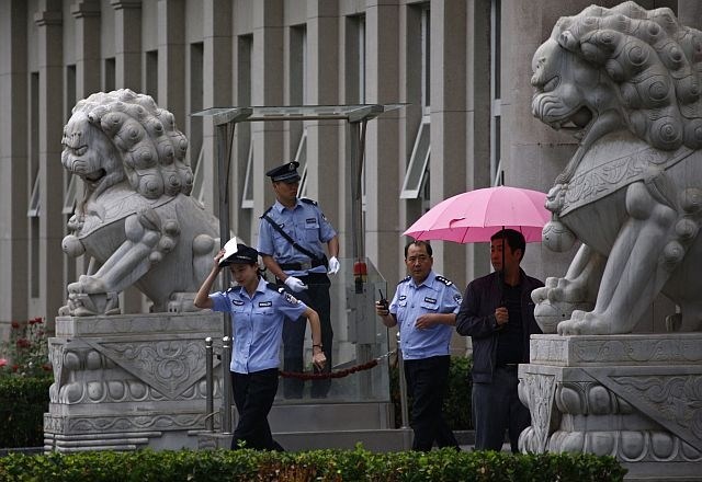 Policisti pred sodiščem, kjer so sodili Liuju Huiju (foto: Reuters) 
