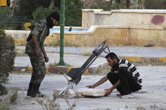 Sirski uporniki v mestu Deir al-Zour za izstrelitev pripravljajo raketo.  Foto: Reuters 