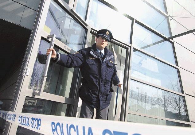 Policist pred nekdanjo poslovno stavbo finančne družbe Orion 