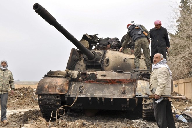 Pripadniki kurdskih zaščitniških enotna severu Sirije pregledujejo tank, ki ga je napadel samomorilski bombaš najmočnejše...