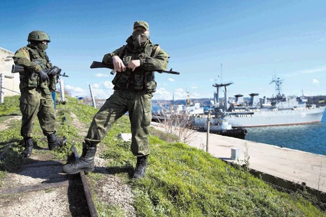 Ruska vojaka v Sevastopolu stražita pomol z zasidranima ukrajinskima vojaškima ladjama. 