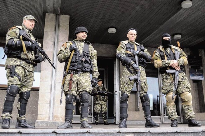 Proruski aktivisti, kot jim pravijo, stražijo pred zasedeno stavbo v Slavjansku, ki so ga razglasili za del samooklicane...