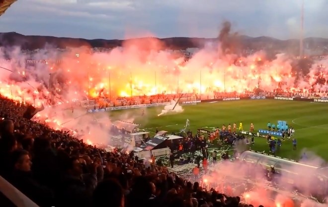 Pred začetkom tekme je zagorelo na tribunah solunskega stadiona Tumbas. (Foto: Youtube) 