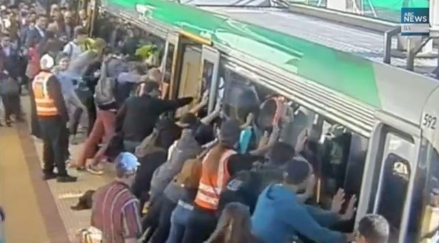 S skupnimi močmi privzdignili vagon vlaka in rešili ujetega potnika (video dneva)