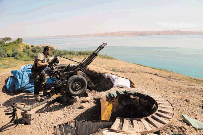 Kurdski vojak pripravlja top v bližini Mosula, kjer so potekali boji za nadzor nad jezom. 
