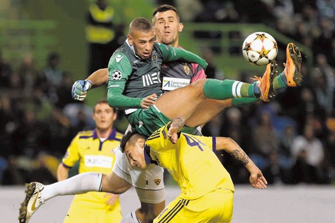 Nogometaši Maribora (v rumenih majicah) so sinoči v Lizboni bili oster boj z igralci Sportinga. AP 