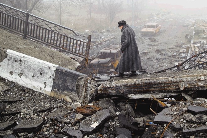 Ženska koraka po ostankih porušenega mosta v Donecku blizu letališča, kjer so potekali eni najhujših spopadov v vojni. 