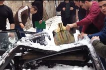 Video: Z zgradbe padel sneg in popolnoma uničil avtomobil, voznik preživel