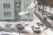 Sneg s strehe bloka močno potolkel avtomobile na parkirišču