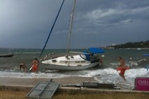 Močan veter je odkrival strehe in ruval drevesa; na Obali reševali plavalca in jadralca (foto)