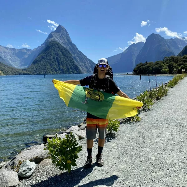 Janez Mikec s šentjernejsko zastavo na pohodu po Milford Soundu na Južnem otoku. 