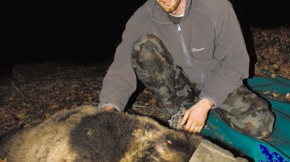 Predsednik dru&scaron;tva Dinaricum Miha Krofel v družbi medvedke Ane, ki so jo ulovili na Rakitni in ji namestili telemetrično ovratnico.