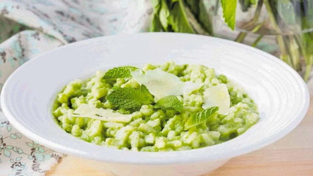 Italijanska zelena rižota, risi e bisi, z na zob kuhanim mladim grahom, parmezanom in lističi poprove mete je izjemno okusna.