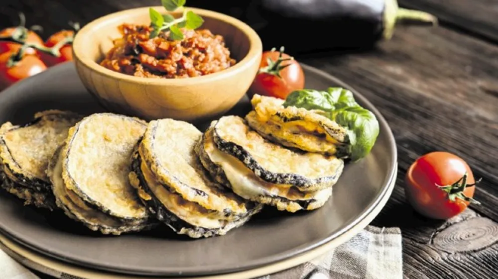 K rezinam jajčevca, polnjenim s sirom in ocvrtim, se odlično prileže paradižnikova omaka.