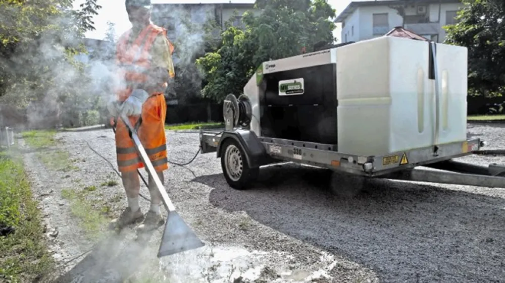 Zatiranje plevela na otro&scaron;kem igri&scaron;ču na Novih Poljanah z novim strojem na paro in biolo&scaron;ko razgradljivo me&scaron;anico. Po uporabi podobno kot pri herbicidu plevel odmre.