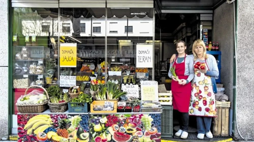 Gordana Majnik, lastnica trgovine Sadje-zelenjava v Nazorjevi ulici, in prodajalka Rada gostom postrežeta v vrečkah, kot so jih uporabljali že pred desetletji.