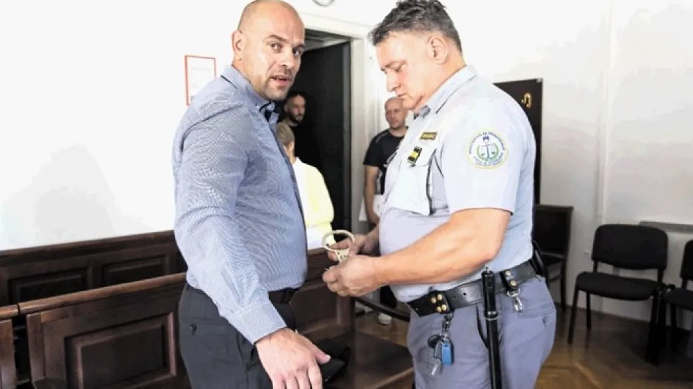 Olega Đajića so iz pripora pripeljali z vklenjenimi rokami in nogami. Prve lisice so mu v sodni dvorani odklenili, drugih pa zaradi varnosti raje ne.