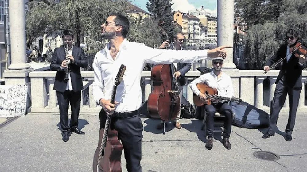 Teo Collori in Momeno Cigano na enem od uličnih nastopov na Čevljarskem mostu. &raquo;Na ulici se ti zgodi absolutna streznitev; ljudje se preprosto ne ustavijo, če jih ne zintrigira&scaron;, fascinira&scaron; z nečim,&laquo; je prepričan kitarist in skladatelj Teo Collori. Eden od prijemov je tudi ta, da se elegantno oblečejo.