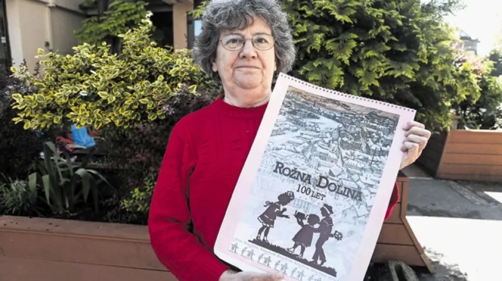 Živa Vidmar začne zgodbo o Rožni dolini pripovedovati s spominskim albumom v rokah.