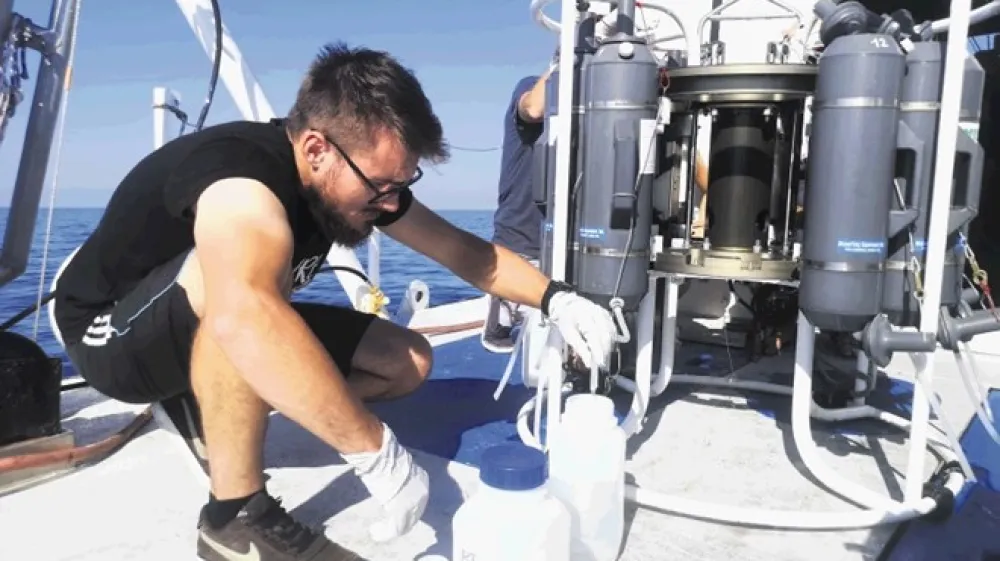 Leon Lojze Zamuda med shranjevanjem vzorcev morja iz Niskinovih vzorčevalnikov