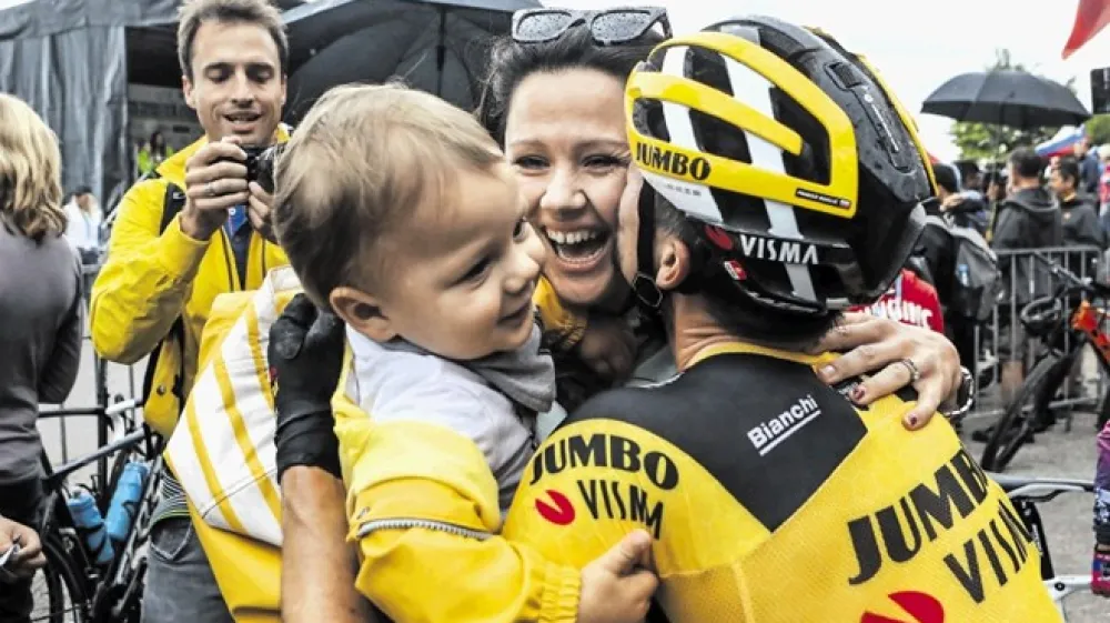 Slovenski kolesar Primož Roglič (desno) v objemu življenjske sopotnice Lore Klinc in njunega sina Leva.