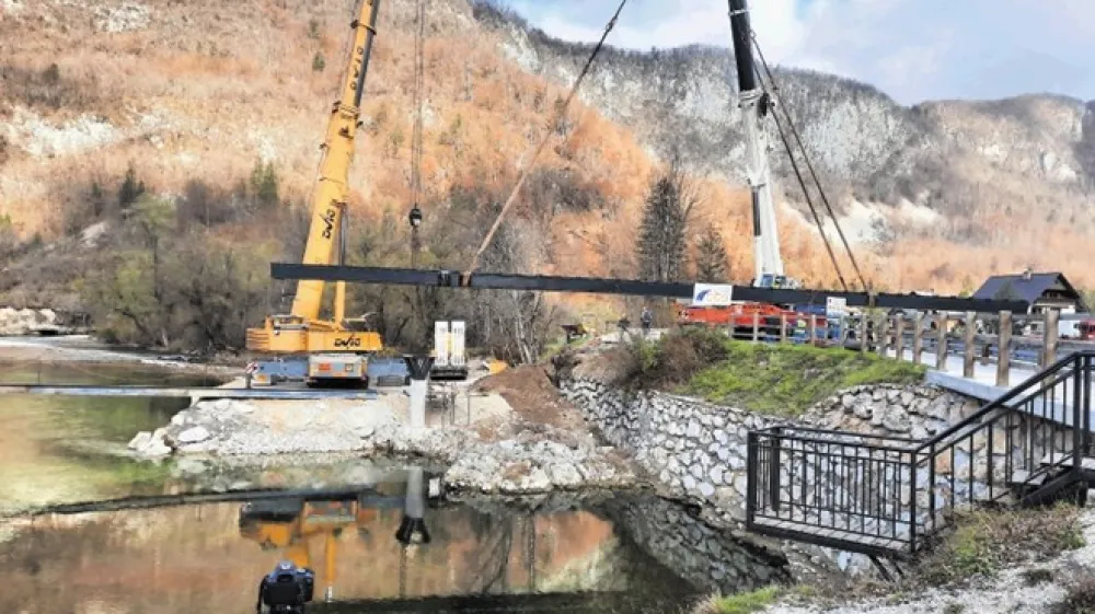 Name&scaron;čanje jeklene konstrukcije mostu, ki je v vasi Kamnje v Bohinju povezala levi in desni breg Save Bohinjke.