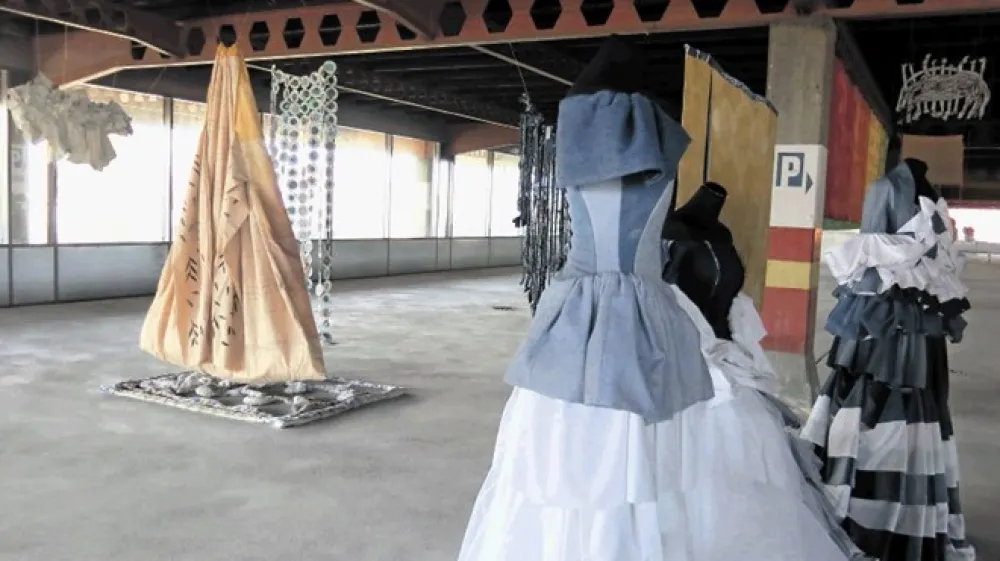 Nekdanja garaža veleblagovnice je  za javnost odprta po več letih, v praznem prostoru, posejanem z betonskimi stebri, pa so oživele tekstilne instalacije.